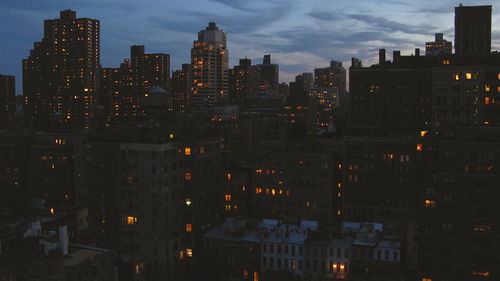 Buildings in city against cloudy sky