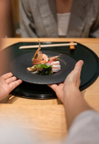 Midsection of woman holding food on table