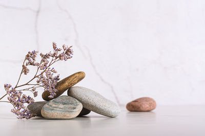 Beautiful composition of smooth sea stones and dried flowers on the table