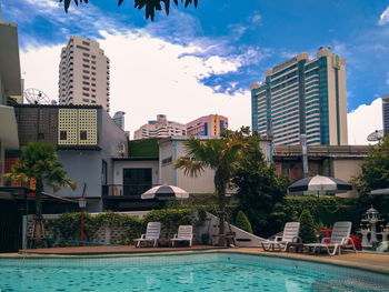 Swimming pool in city against sky