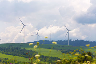 Windmill on field against sky