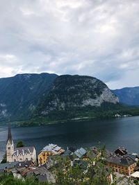 Scenic view of lake by buildings against sky