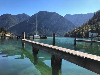 Scenic view of lake and mountains against clear blue sky