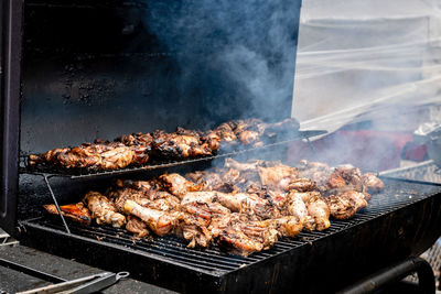 Grilled chicken thigh and legs over flames on a barbecue