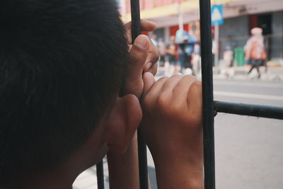 Close-up of boy looking through window