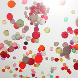 Low angle view of multi colored balloons against white background