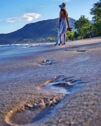 Full length of woman walking on road against sky