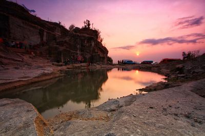 Scenic view of sea by buildings against sky during sunset