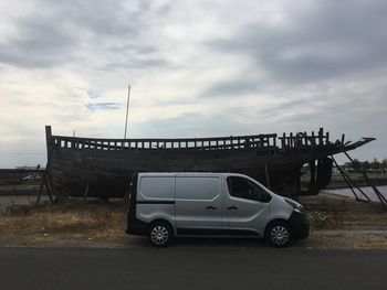 Car on road against cloudy sky