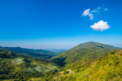 Scenic view of mountains against blue sky