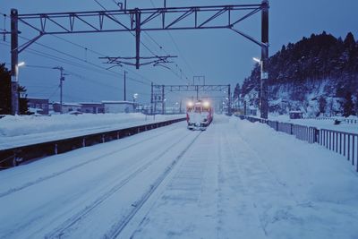 Snow covered railroad tracks against sky