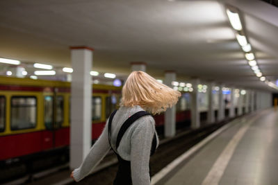 Side view of woman standing at railroad station platform