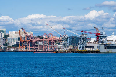 Commercial dock by sea against sky