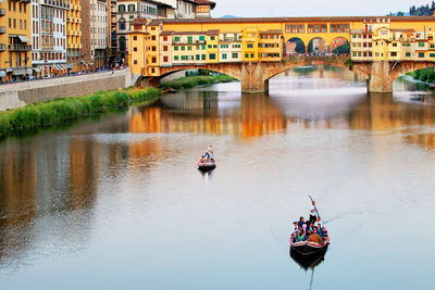 People on bridge over river in city