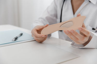 Midsection of woman holding insole