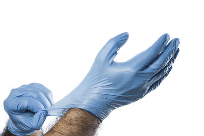 Close-up of hand holding paper over white background