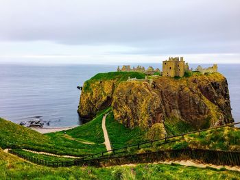 Fort on mountain by sea against sky