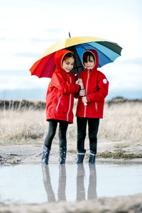 Full length of woman standing on wet umbrella during rainy season