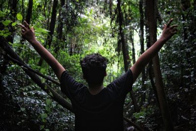 Rear view of man standing in forest
