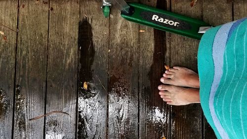 Low section of man standing on wooden plank