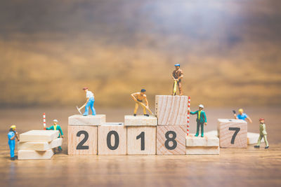 Miniature  people working on wooden blocks 