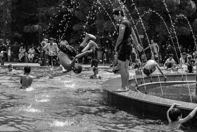 People in swimming pool against trees