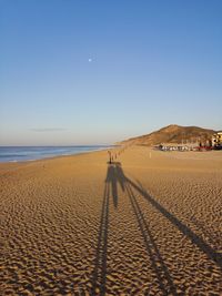 Panoramic view of people on beach against clear sky