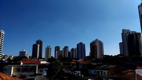 Buildings in city against blue sky