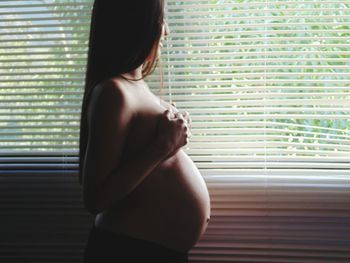 Rear view of woman looking through window