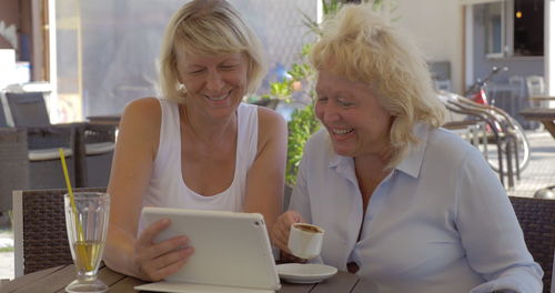 Happy woman sitting on table at home