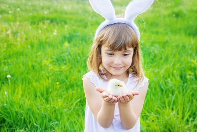 Portrait of young woman standing on grassy field