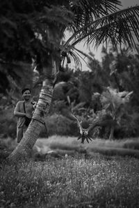 Man standing on field against trees