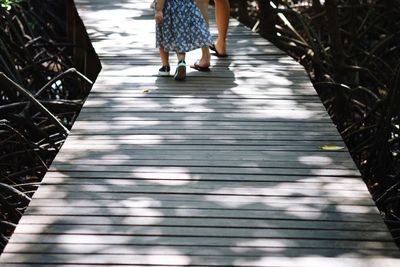 Low section of women walking on footpath