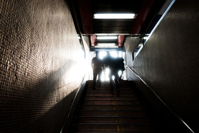 Rear view of people walking on stairs