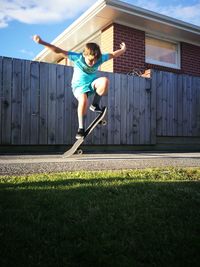 Full length of man jumping in front of building