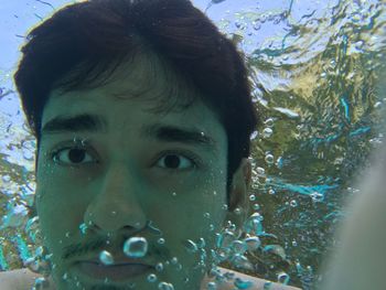 Close-up portrait of woman swimming in water
