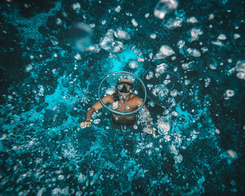 High angle view of man swimming in abyss of the ocean making water rings
