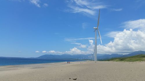 Scenic view of beach, windmill and the sky