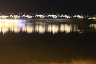 Scenic view of lake against sky at night