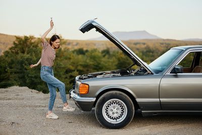 Full length of young man holding car