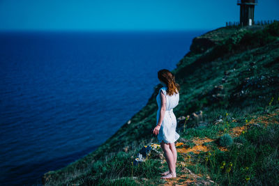 Full length of young woman standing in sea