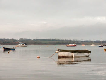 Boats moored on sea against sky