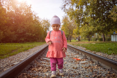 Full length of girl standing on railroad track