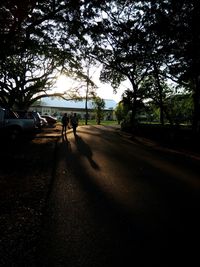 Rear view of silhouette people walking on road