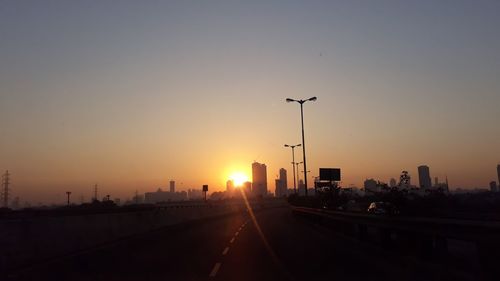 Silhouette road against sky during sunset