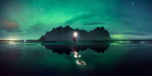 Scenic view of lake against sky at night