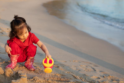 Cute girl playing with toy on beach