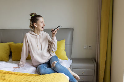 Portrait of young woman sitting on floor at home