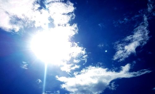 Low angle view of sun shining in sky