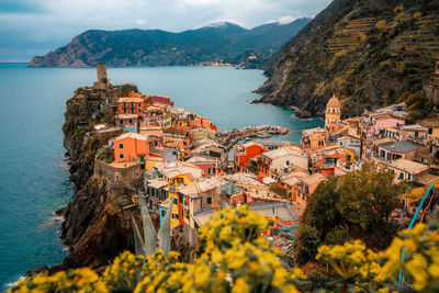 High angle view of townscape by sea against mountain